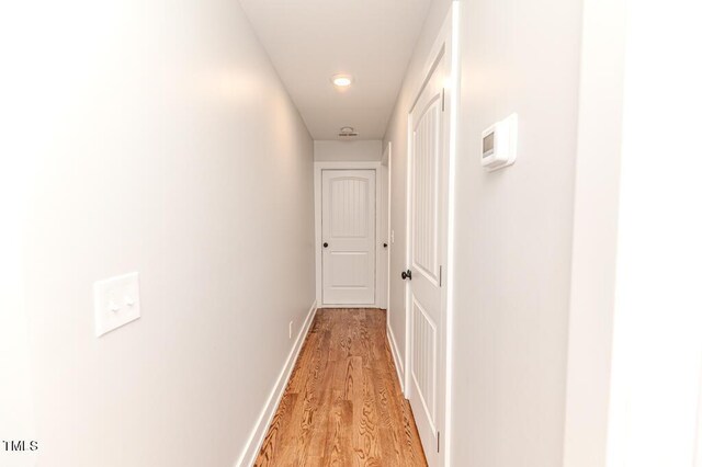 hallway with light wood-style flooring and baseboards