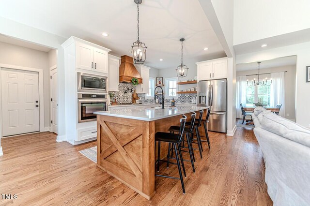 kitchen featuring light countertops, a chandelier, light wood-style floors, and appliances with stainless steel finishes