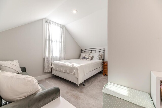 carpeted bedroom with baseboards and vaulted ceiling