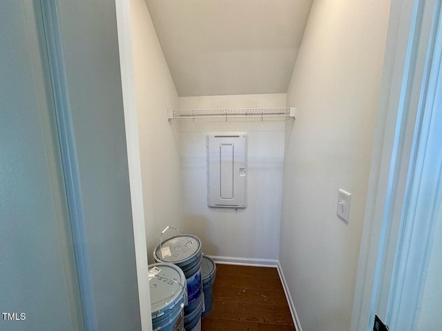 washroom with electric panel, baseboards, and dark wood-type flooring