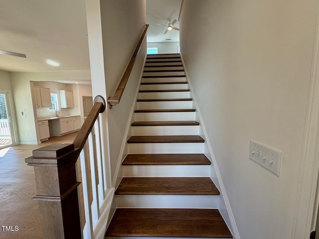 staircase with baseboards, visible vents, and a ceiling fan