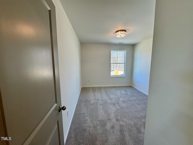 empty room featuring carpet floors and baseboards