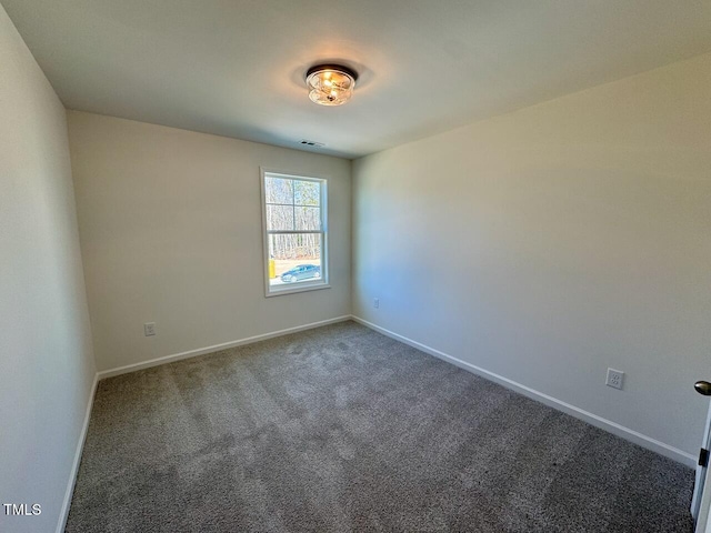 unfurnished room featuring carpet, visible vents, and baseboards