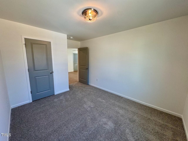 unfurnished bedroom featuring carpet floors and baseboards