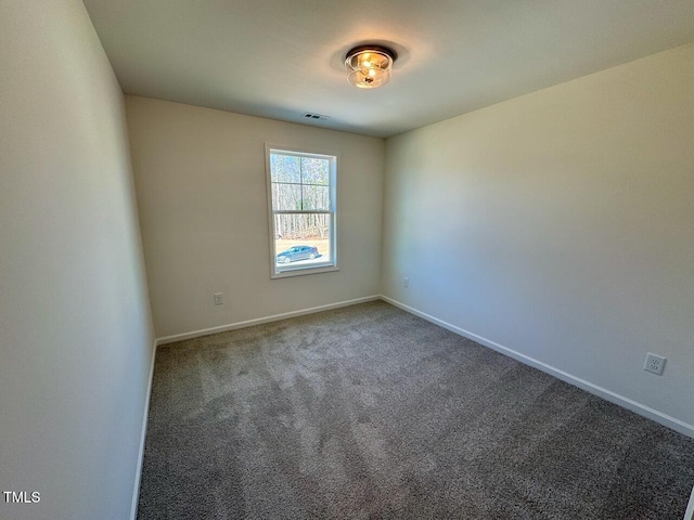 spare room with carpet, visible vents, and baseboards