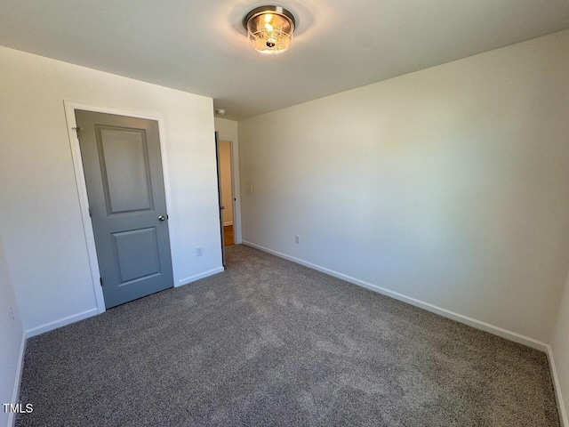 unfurnished bedroom featuring carpet and baseboards