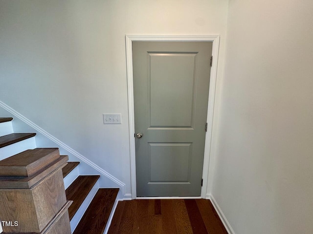 doorway with stairway, wood finished floors, and baseboards