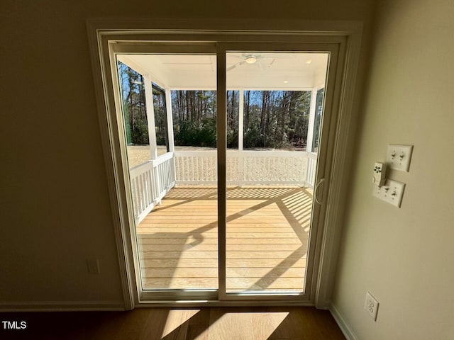 doorway featuring plenty of natural light, wood finished floors, and baseboards