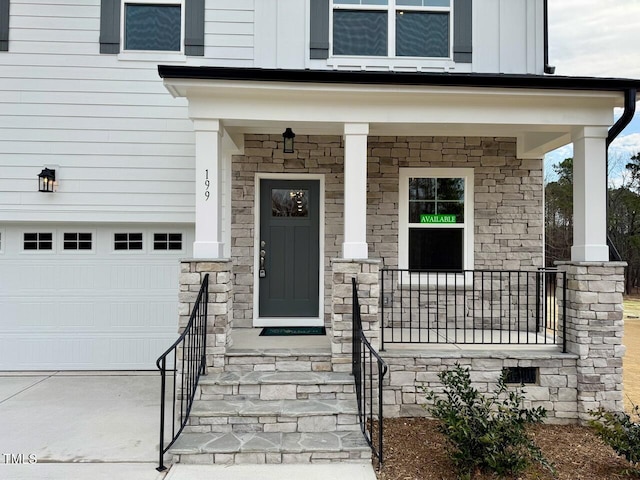 property entrance featuring covered porch, stone siding, and board and batten siding