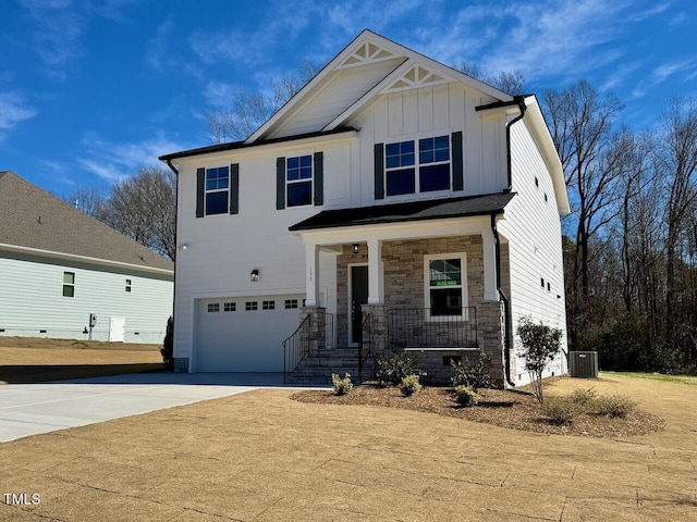 view of front of house featuring driveway, stone siding, covered porch, central air condition unit, and board and batten siding