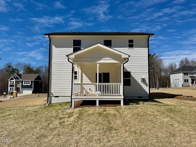 rear view of house with covered porch, crawl space, and a lawn