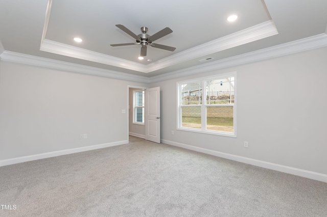 spare room with ceiling fan, crown molding, carpet, and a raised ceiling