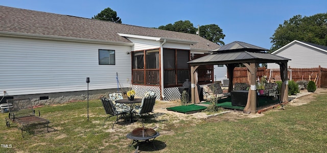 back of property featuring a sunroom, a yard, and a gazebo