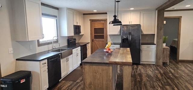 kitchen featuring black appliances, white cabinetry, and hanging light fixtures