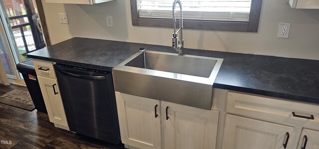 kitchen featuring stainless steel dishwasher, sink, dark hardwood / wood-style flooring, and white cabinets