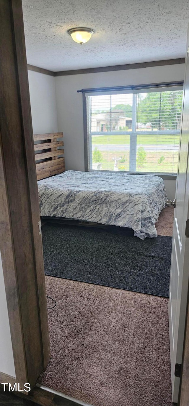 bedroom featuring a textured ceiling and carpet floors