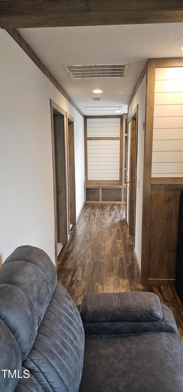 hallway featuring dark hardwood / wood-style floors, ornamental molding, and a textured ceiling