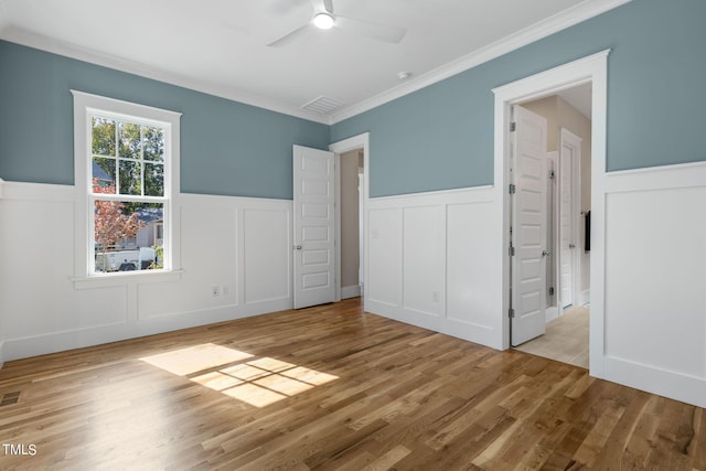 unfurnished bedroom featuring crown molding, light wood-type flooring, and ceiling fan