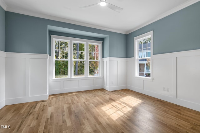 empty room featuring crown molding, ceiling fan, light wood-type flooring, and plenty of natural light