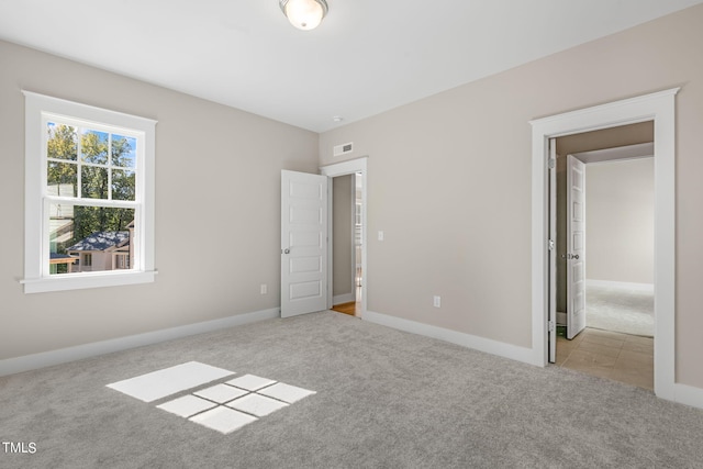 unfurnished bedroom featuring light carpet