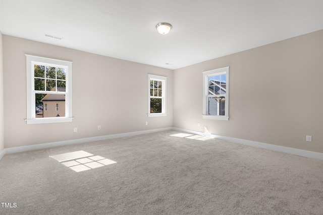 empty room with a healthy amount of sunlight and carpet floors