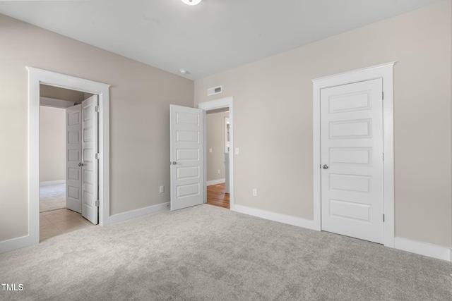 unfurnished bedroom with light colored carpet