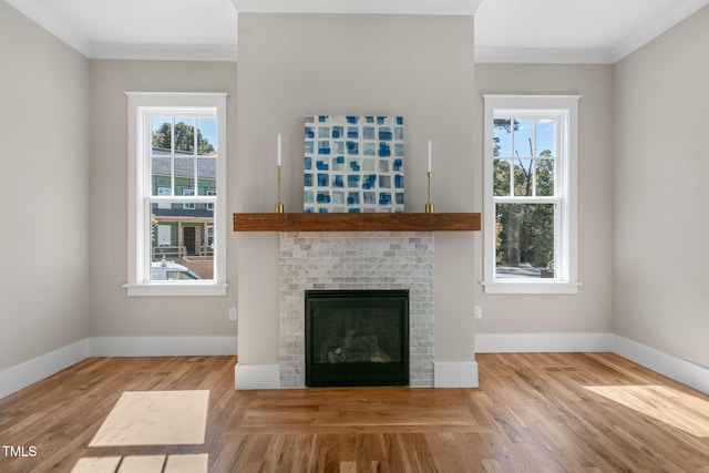 unfurnished living room with crown molding, a brick fireplace, and hardwood / wood-style flooring