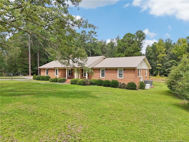 ranch-style home featuring a front yard and central AC unit