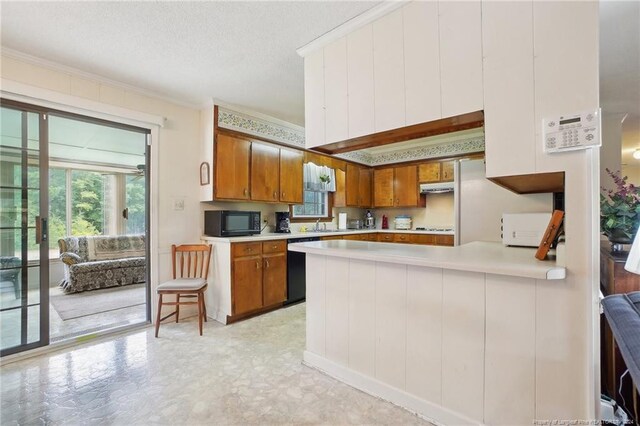 kitchen with ornamental molding, black appliances, a textured ceiling, and kitchen peninsula