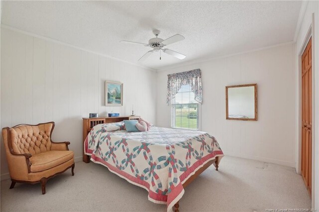 bedroom with light carpet, a closet, ceiling fan, ornamental molding, and a textured ceiling