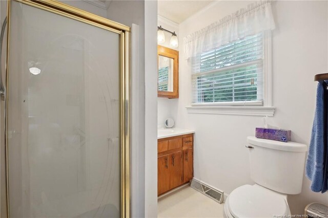 bathroom featuring an enclosed shower, toilet, and vanity