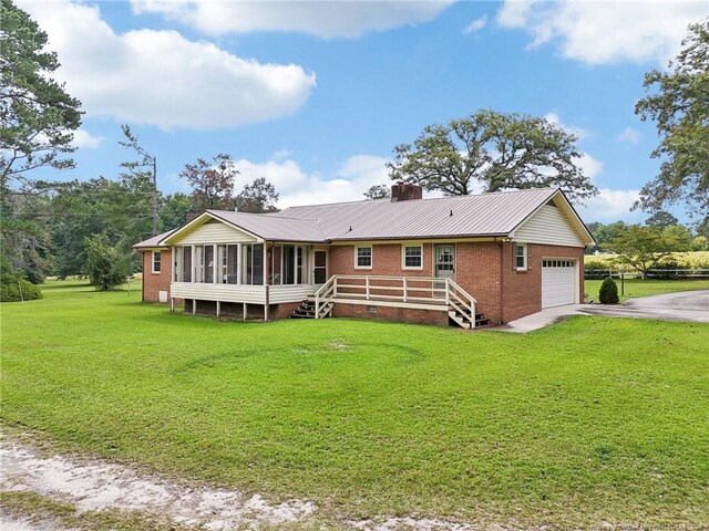 ranch-style house with a garage, a sunroom, and a front lawn