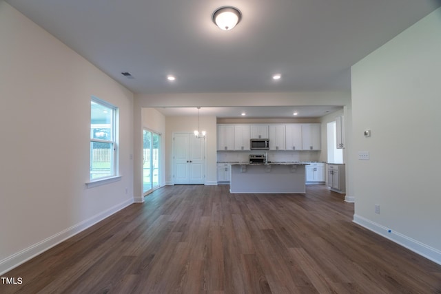unfurnished living room featuring visible vents, baseboards, recessed lighting, dark wood-type flooring, and an inviting chandelier