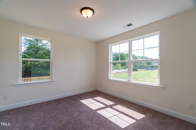 unfurnished room with baseboards, visible vents, and carpet