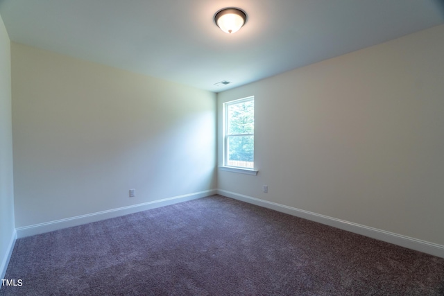 carpeted empty room featuring baseboards and visible vents