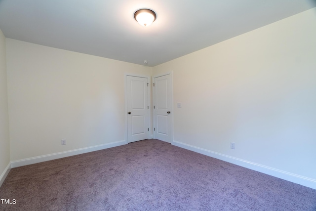 spare room featuring baseboards and carpet