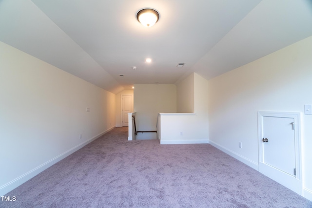 unfurnished room with baseboards, vaulted ceiling, visible vents, and carpet