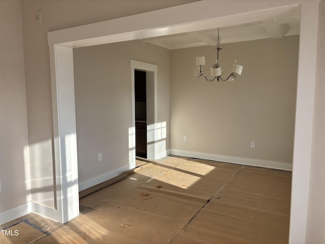 spare room with an inviting chandelier, beam ceiling, and coffered ceiling