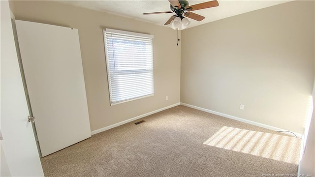 carpeted empty room featuring ceiling fan