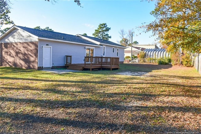 rear view of property featuring a yard and a deck