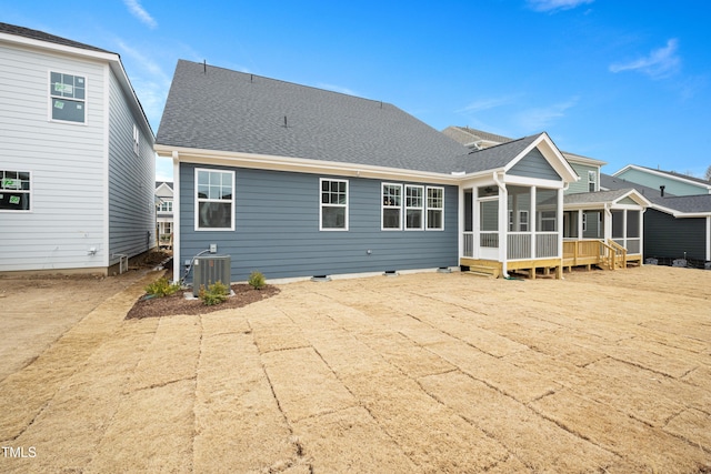 rear view of house with central AC unit, a patio area, and a sunroom