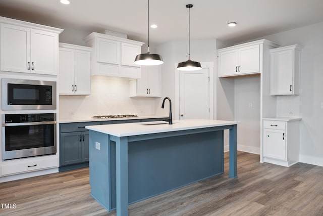 kitchen with white cabinetry, appliances with stainless steel finishes, sink, and pendant lighting