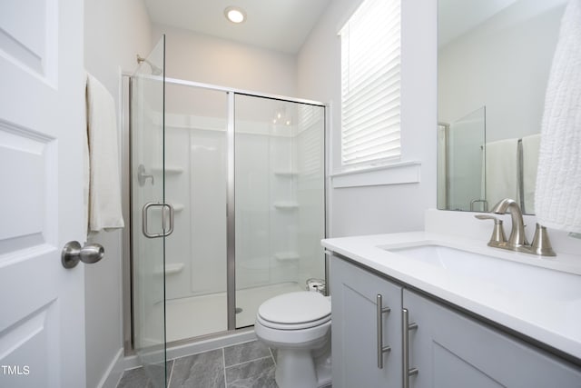 bathroom featuring walk in shower, vanity, and toilet