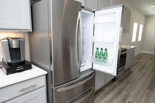 kitchen with white cabinets, stainless steel range, backsplash, and dark wood-type flooring