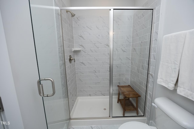 bathroom featuring an enclosed shower and toilet