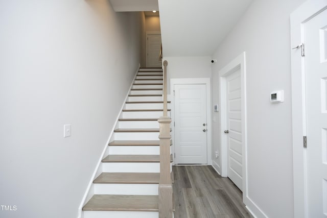 staircase with hardwood / wood-style floors