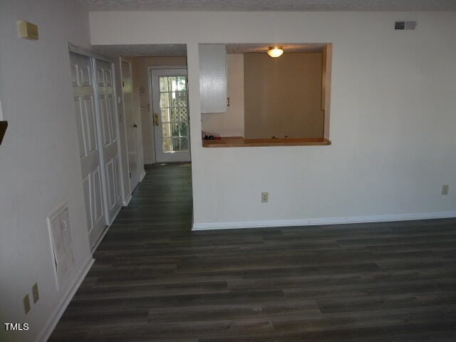 unfurnished room featuring dark wood-type flooring