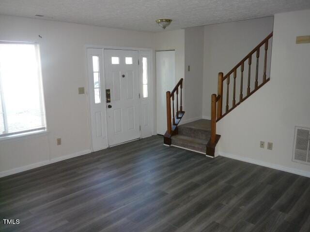 8220 Mcguire Dr, Raleigh, NC 27616 - foyer featuring stairs, visible vents, a healthy amount of sunlight, and dark wood finished floors