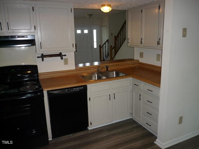 kitchen with black appliances, exhaust hood, sink, and white cabinetry