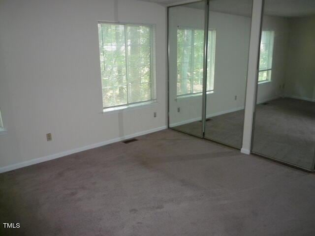 8220 Mcguire Dr, Raleigh, NC 27616 - unfurnished bedroom featuring visible vents, carpet, baseboards, and two closets